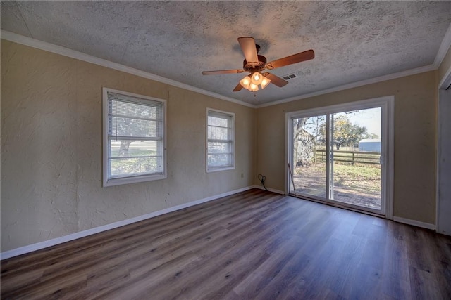 empty room with a textured ceiling, dark wood-type flooring, and ornamental molding