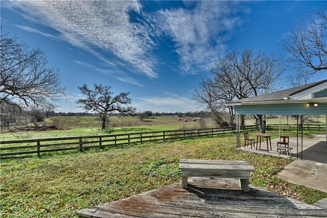 view of yard with a patio area, a rural view, and a wooden deck