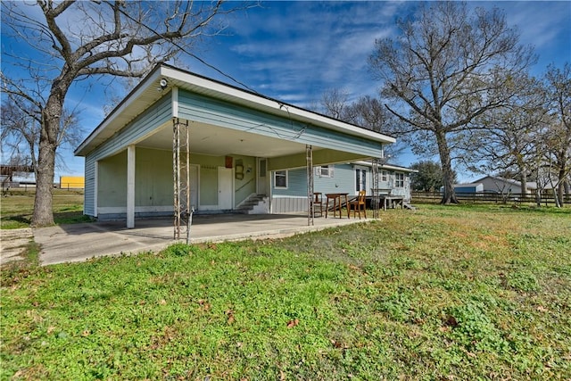 back of property with a yard and a carport