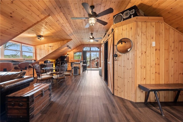 interior space featuring lofted ceiling, dark hardwood / wood-style flooring, wooden walls, and wooden ceiling