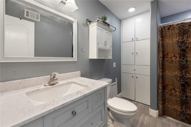 bathroom featuring hardwood / wood-style flooring, vanity, and toilet