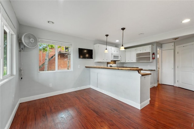 kitchen featuring pendant lighting, wooden counters, white cabinets, dark hardwood / wood-style floors, and kitchen peninsula