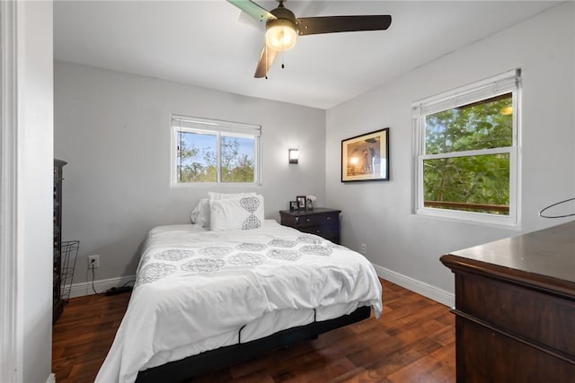 bedroom with multiple windows, dark wood-type flooring, and ceiling fan