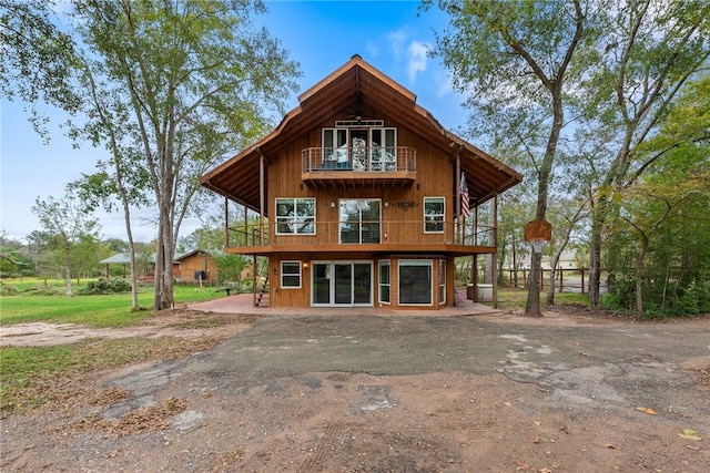 rear view of property featuring a balcony and a patio area