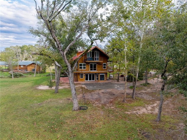 rear view of property featuring a lawn and a patio area