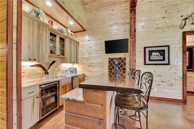 15184 Fm 2620, Bedias, TX 77831 - bar with wine cooler, wood walls, stainless steel dishwasher, finished concrete floors, and recessed lighting