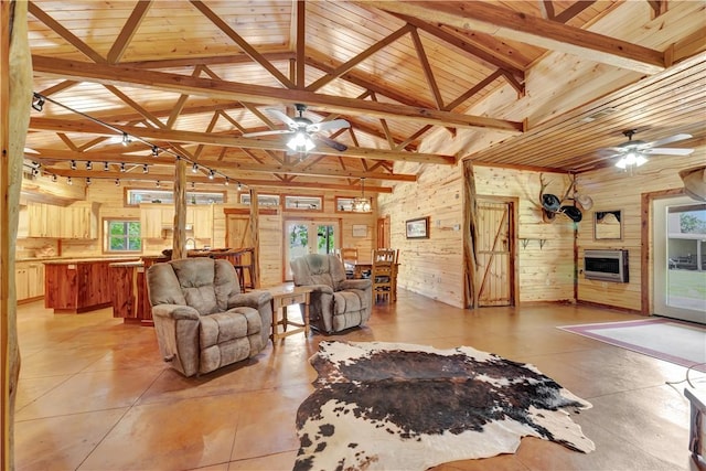 15184 Fm 2620, Bedias, TX 77831 - living room featuring ceiling fan, wooden walls, heating unit, plenty of natural light, and lofted ceiling