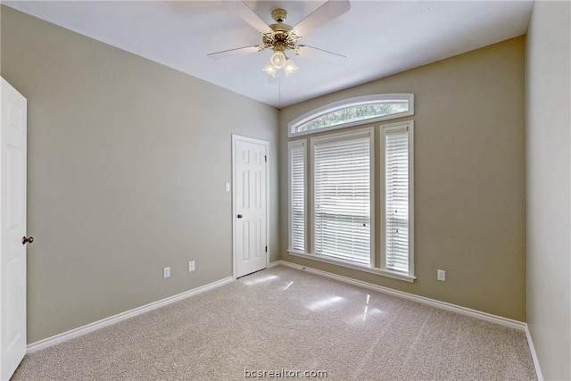 unfurnished room with light colored carpet and ceiling fan