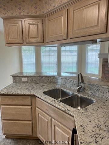 kitchen featuring light stone countertops and sink