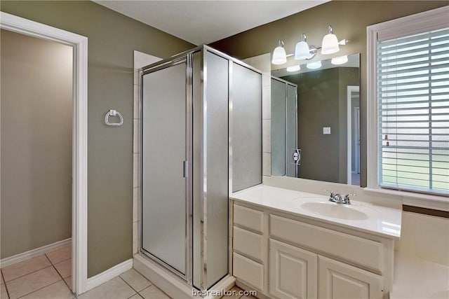 bathroom with tile patterned flooring, vanity, and walk in shower