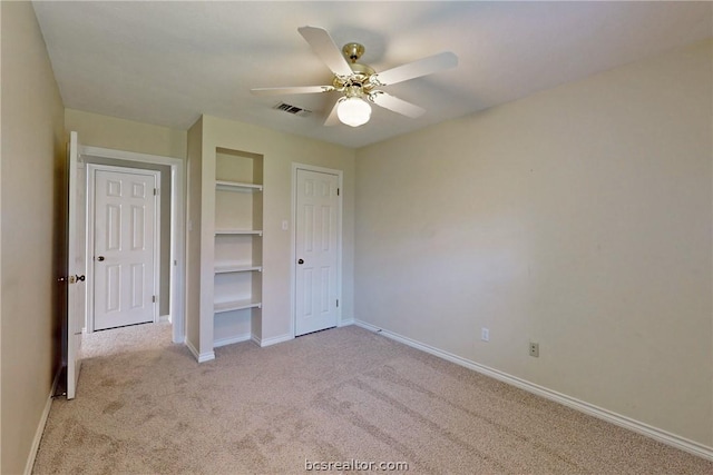 unfurnished bedroom featuring ceiling fan, a closet, and light carpet