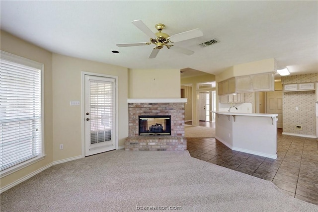 unfurnished living room featuring a wealth of natural light and dark carpet