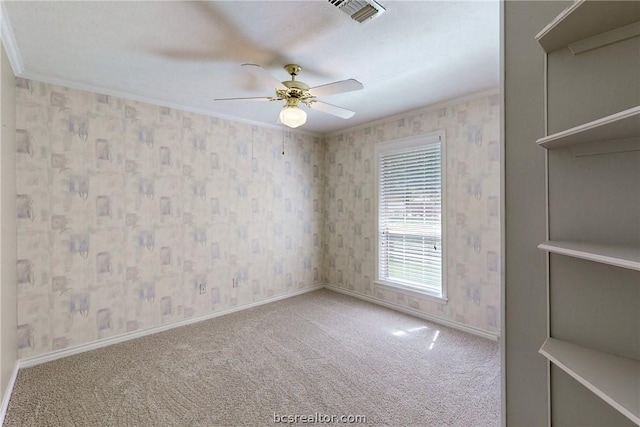 carpeted empty room featuring ceiling fan and crown molding