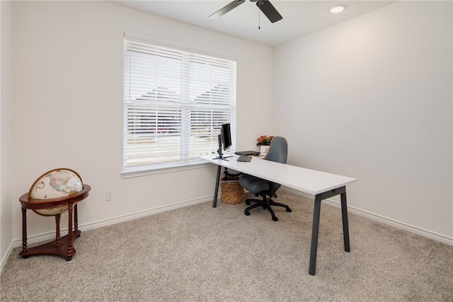 home office with light carpet, ceiling fan, and baseboards