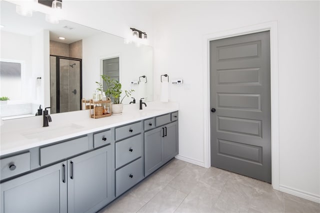 full bathroom with double vanity, a sink, and a shower stall