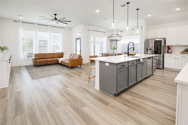 kitchen with appliances with stainless steel finishes, white cabinets, light countertops, and gray cabinetry