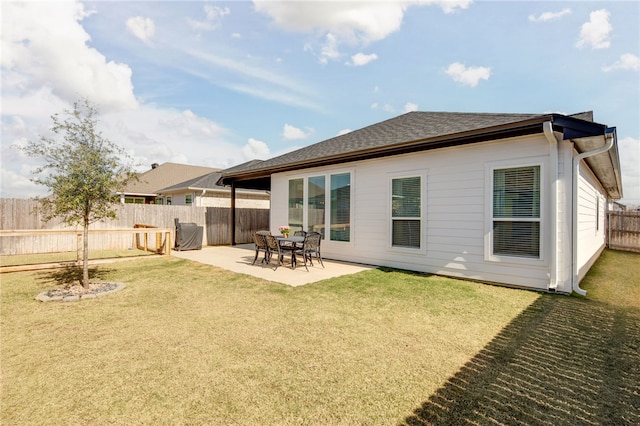 rear view of property with a patio, a lawn, a fenced backyard, and roof with shingles