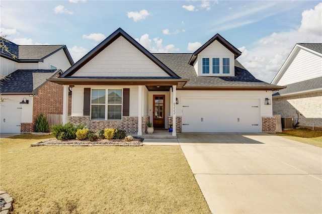 craftsman inspired home with driveway, a shingled roof, central AC unit, a front lawn, and brick siding