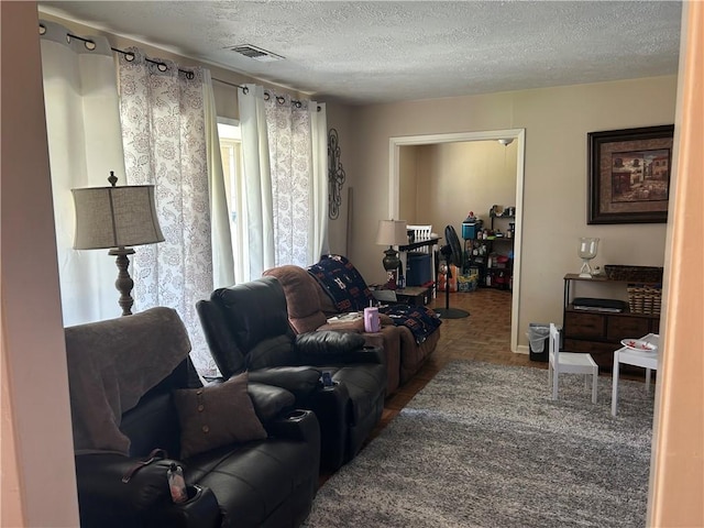 living area with a textured ceiling and visible vents