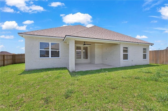 rear view of property with a yard, ceiling fan, and a patio area