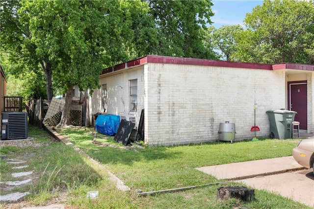 view of home's exterior featuring central air condition unit and a lawn