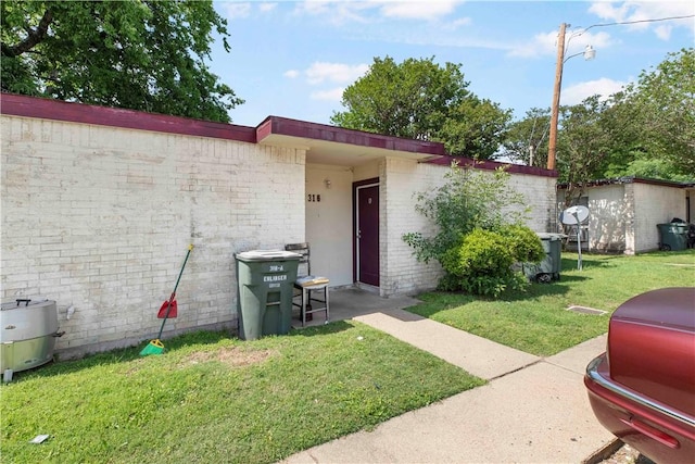 entrance to property featuring a lawn