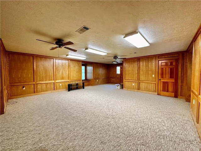 unfurnished room with ceiling fan, a textured ceiling, and light carpet