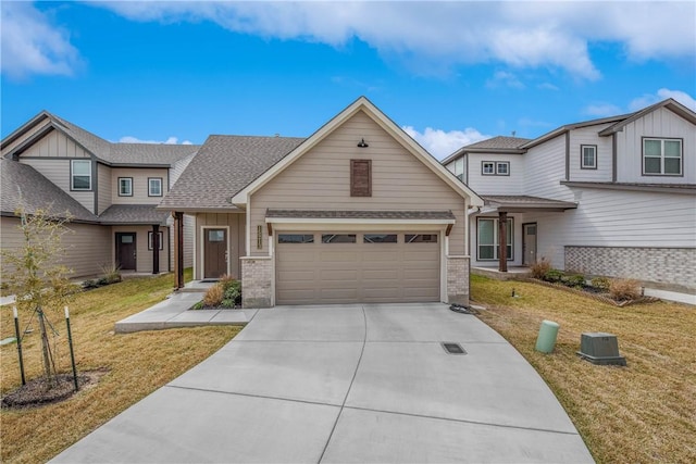 view of front facade featuring concrete driveway, board and batten siding, an attached garage, a front yard, and brick siding