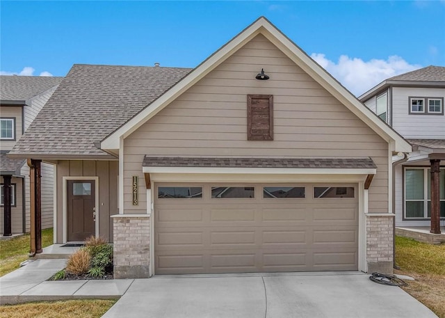 view of property featuring an attached garage, driveway, and roof with shingles