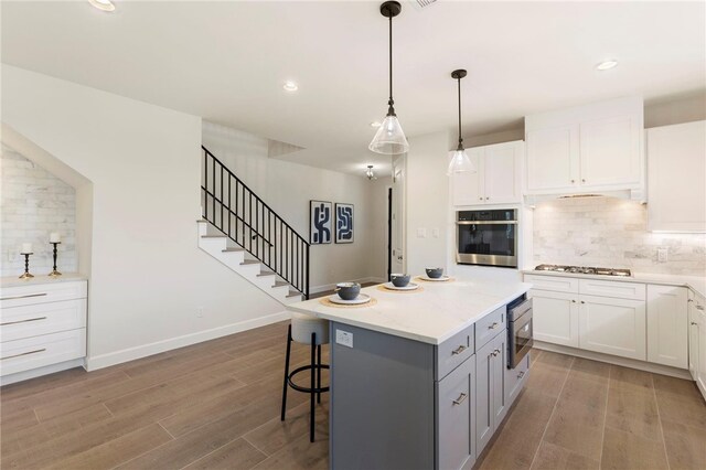 3223 Tamy Ln, Brenham, TX 77833 - kitchen with stainless steel appliances, tasteful backsplash, a kitchen bar, light wood-type flooring, and recessed lighting