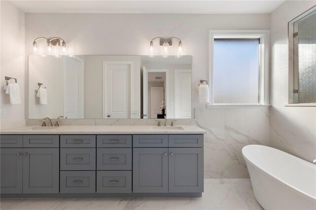 3223 Tamy Ln, Brenham, TX 77833 - bathroom featuring marble finish floors, double vanity, and a soaking tub