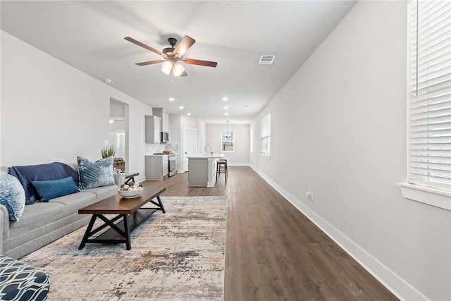 living room with wood finished floors, baseboards, visible vents, recessed lighting, and ceiling fan