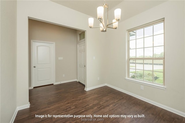 unfurnished room featuring a chandelier, dark hardwood / wood-style floors, and a wealth of natural light