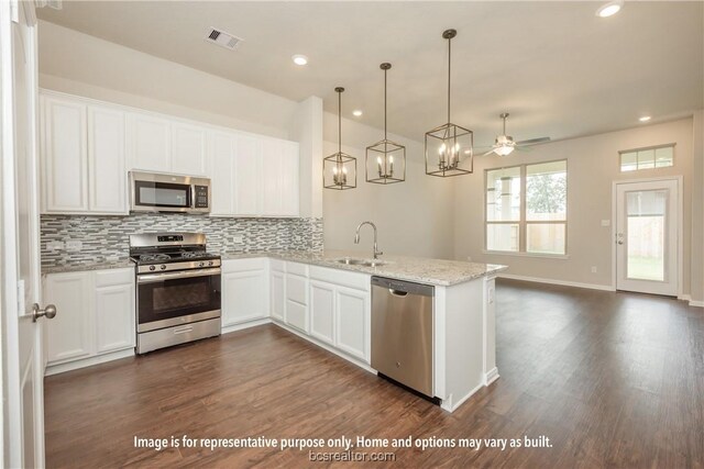 kitchen with light stone counters, stainless steel appliances, ceiling fan, dark wood-type flooring, and white cabinets