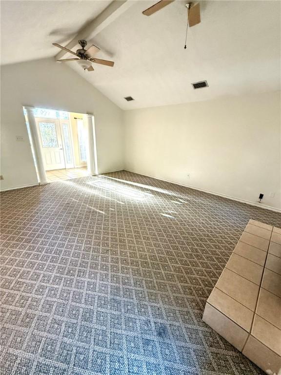 unfurnished room with carpet, lofted ceiling with beams, and ceiling fan