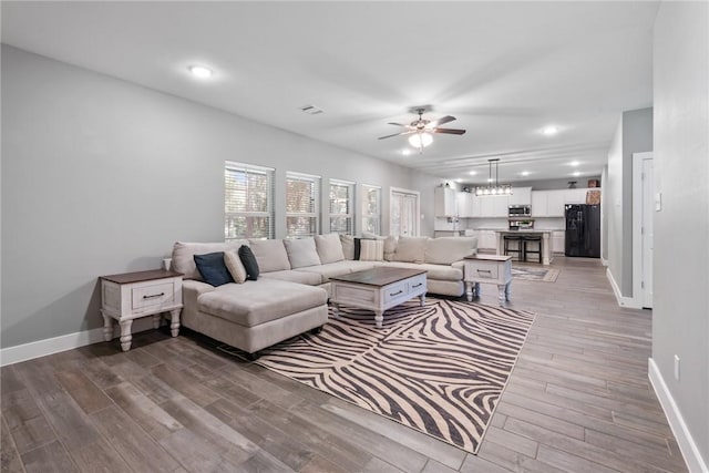 8729 Nathan Dr, Waller, TX 77484 - living room featuring a ceiling fan, light wood finished floors, recessed lighting, and a chandelier
