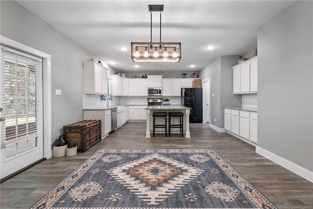 8729 Nathan Dr, Waller, TX 77484 - kitchen featuring appliances with stainless steel finishes, dark wood-style flooring, backsplash, white cabinetry, and recessed lighting