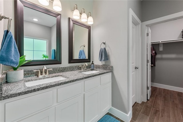 8729 Nathan Dr, Waller, TX 77484 - full bath featuring double vanity, a spacious closet, and wood finished floors