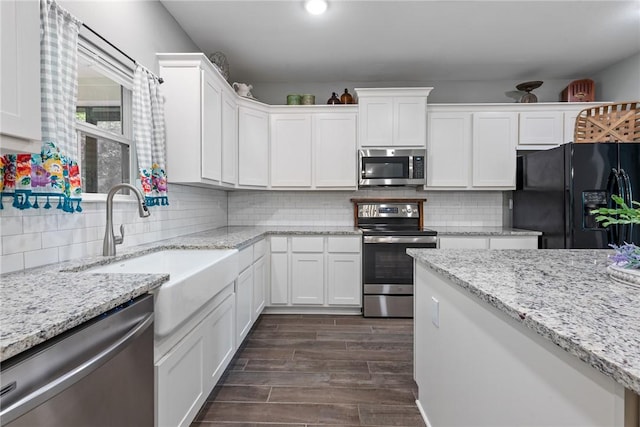 8729 Nathan Dr, Waller, TX 77484 - kitchen featuring stainless steel appliances, white cabinets, dark wood finished floors, and tasteful backsplash