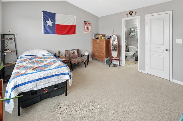 bedroom featuring lofted ceiling, carpet floors, and connected bathroom