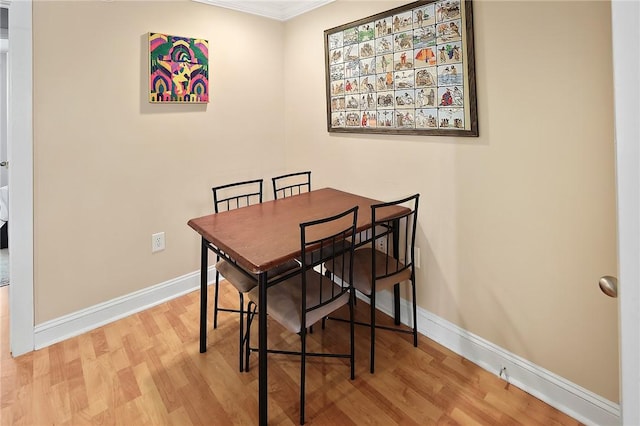 dining room featuring crown molding and light hardwood / wood-style floors