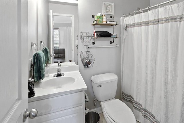 bathroom featuring vanity, toilet, and curtained shower