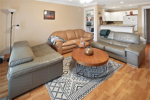 living room featuring built in shelves, ornamental molding, and light hardwood / wood-style floors