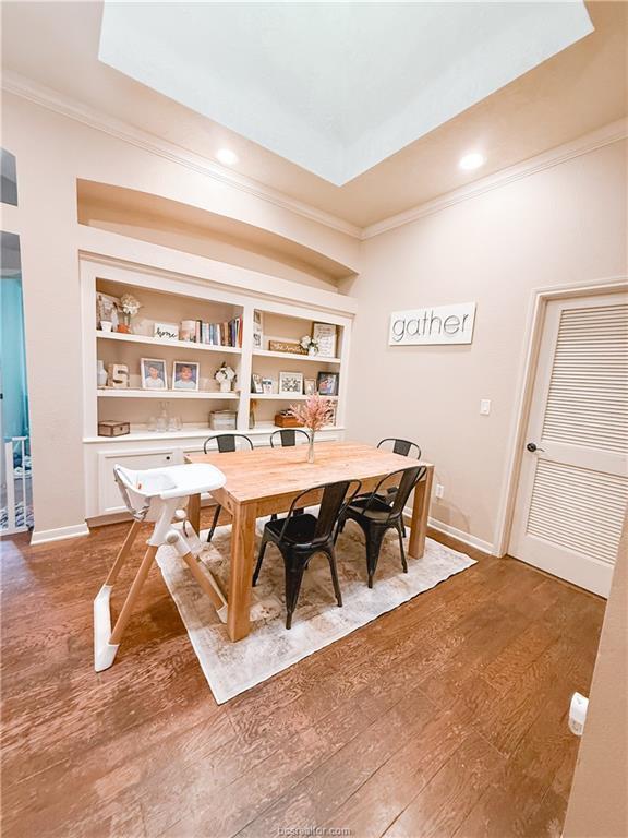 52 Fairway Dr, Normangee, TX 77871 - dining area featuring ornamental molding, wood finished floors, built in shelves, recessed lighting, and a raised ceiling