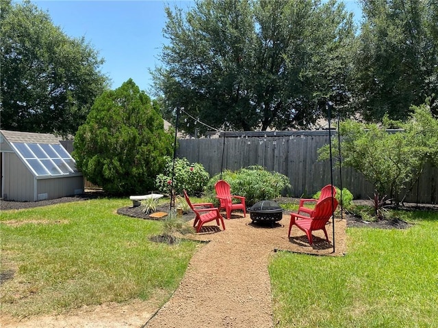 view of yard featuring an outdoor structure and a fire pit