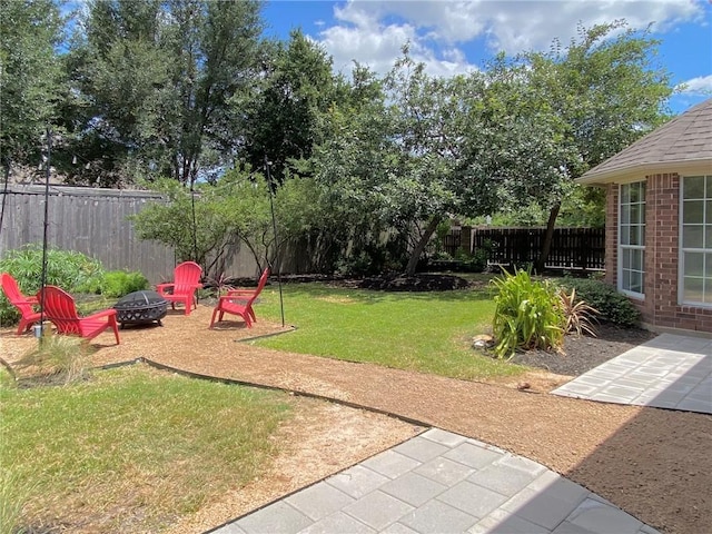 view of yard featuring an outdoor fire pit and a patio area