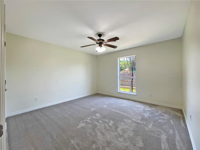 unfurnished room with ceiling fan and carpet