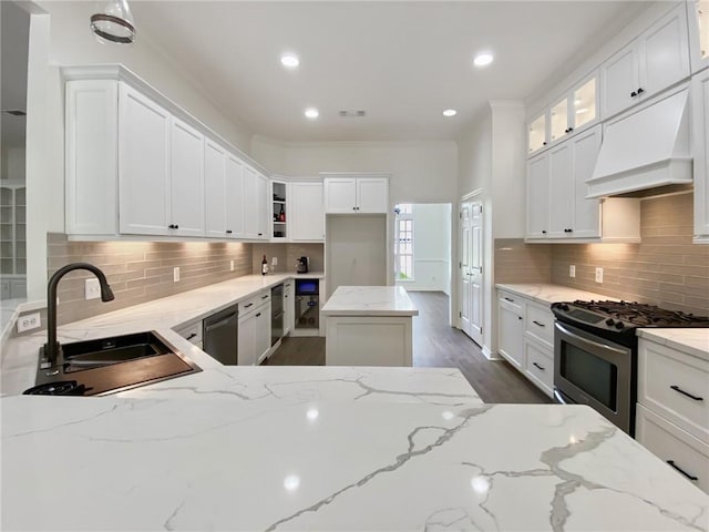 kitchen with decorative backsplash, appliances with stainless steel finishes, light stone counters, and a sink