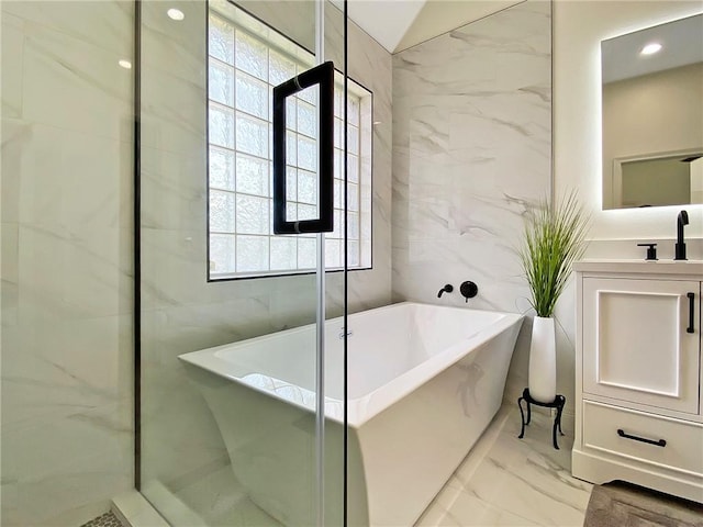 bathroom featuring tile walls, vanity, and a tub