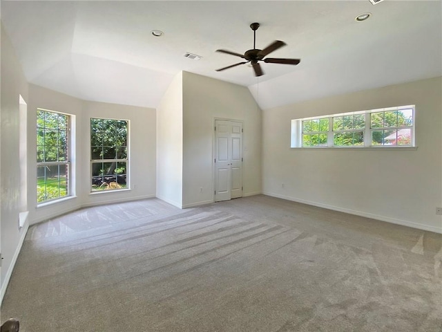 spare room featuring light carpet, lofted ceiling, and ceiling fan